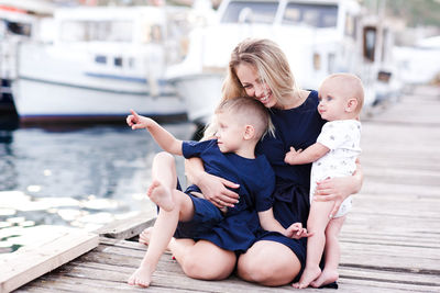 Happy mother holding kid boys outdoors over sea background. happiness. motherhood. 20s.