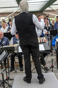 Rear view of people standing on table