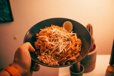 Cropped hand of person preparing food in bowl on table