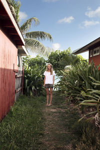 Portrait of happy woman standing amidst beach cabins