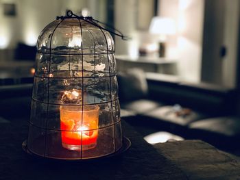 Close-up of lit tea light candle on table at home