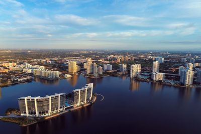 High angle view of buildings by river against sky