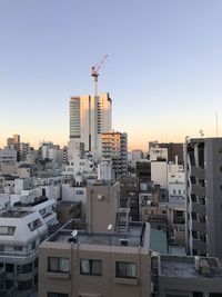 Buildings in city against clear sky