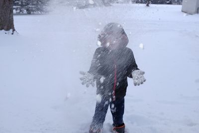 Boy playing with snow at field