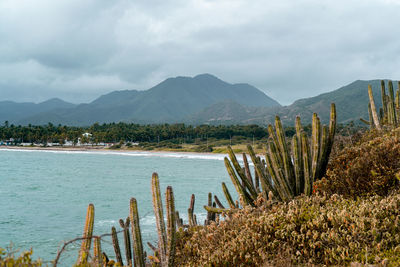 Scenic view of sea and mountains against sky