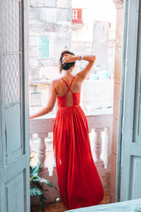 Rear view of woman standing by window