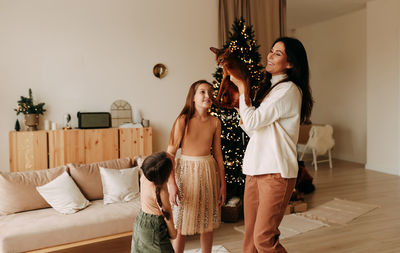 Portrait of young woman holding christmas tree