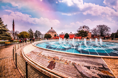 Fountain in swimming pool against building