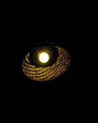 Low angle view of light bulb over black background