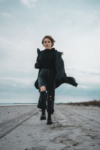 Full length portrait of man standing on beach