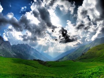 Scenic view of field and mountains against sky