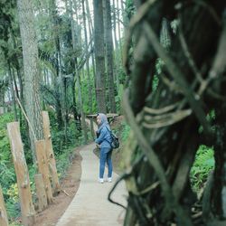 Rear view of woman walking in forest