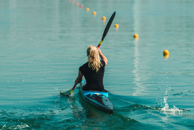 Rear view of woman kayaking in lake