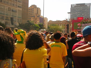 Rear view of people walking on street in city