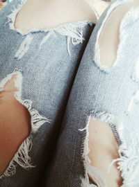 Low section of woman wearing torn jeans