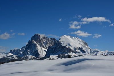 Scenic view of snowcapped mountains against blue sky