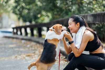 Full length of woman sitting with dog