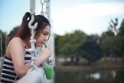 Young woman drinking water from outdoors