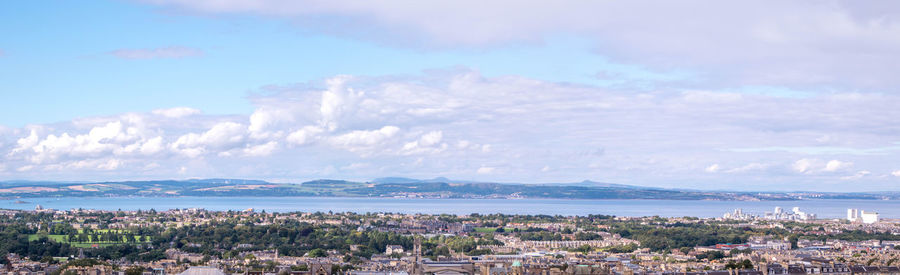 High angle view of city by sea against sky