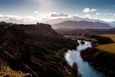 Scenic view of river and mountains against sky