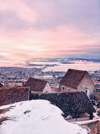 Scenic view of frozen landscape against dramatic sky during sunset