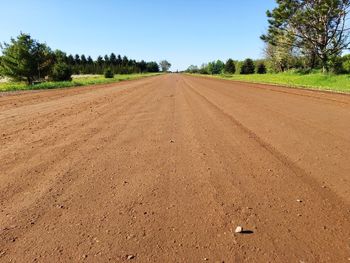 Road amidst field against sky