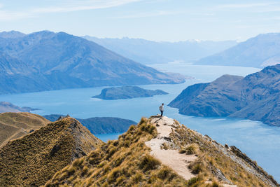 Man hiking amongst mountain views from the roys peak trail, new zealand