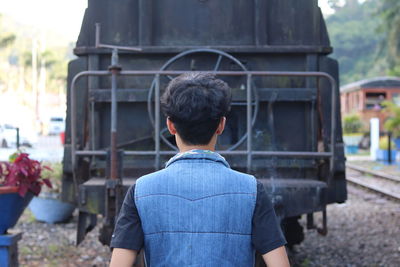 Rear view of man standing against built structure