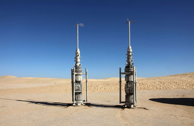 Built structure on countryside landscape against clear blue sky