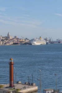 Lighthouse and river bay against sky