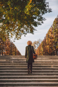 Rear view of woman standing on steps