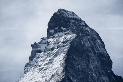 Low angle view of rock formation against sky during winter