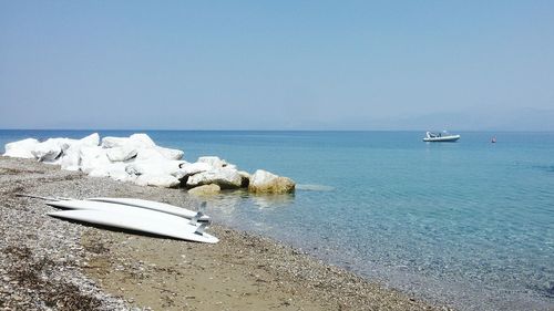 Boats moored on sea against clear sky