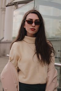 Portrait of young woman in sunglasses standing outdoors