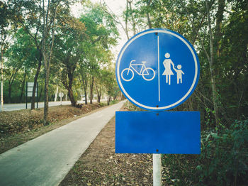 Close-up of road sign against trees
