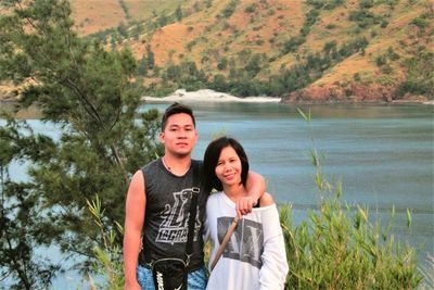 Portrait of smiling young couple standing on mountain