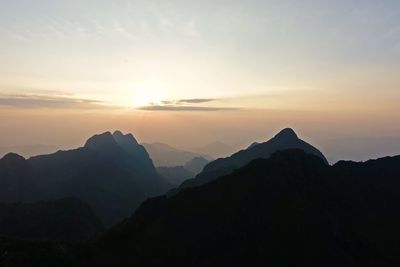 Scenic view of silhouette mountains against sky at sunset