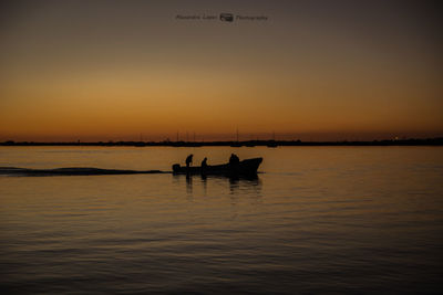 Silhouette boat in sea against sky during sunset