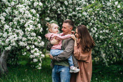 Family mom mom baby daughter in the garden blooming apple trees