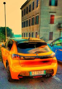 Yellow car on street against buildings in city