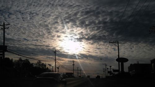 Power lines against cloudy sky