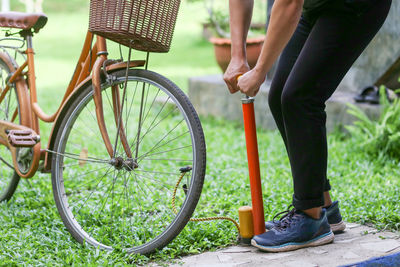 Low section of man riding bicycle on field