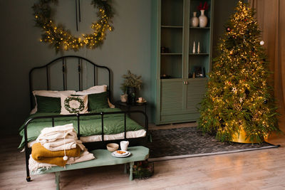 Stylish christmas bedroom in scandinavian style. pillows on the bed and a wreath on the wall