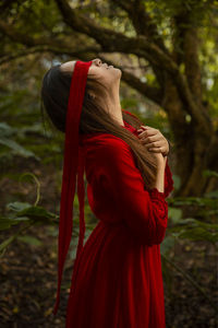 Midsection of woman standing by red tree