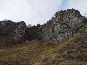 Low angle view of rocks on mountain against sky