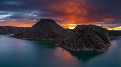 Aerial view of lake and mountain against dramatic sky