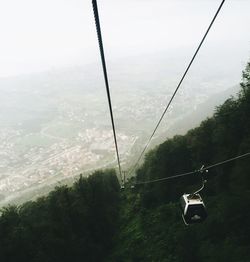 Overhead cable car over sea against sky