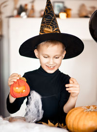 Playful boy wearing hat during halloween