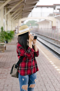 Full length of woman photographing in city