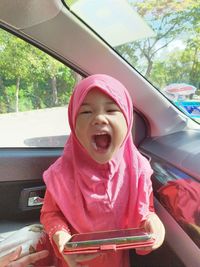 Cute girl smiling while sitting in car